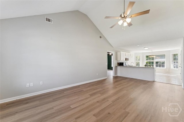 105 Mustang Dr, Guyton, GA 31312 - unfurnished living room featuring high vaulted ceiling, a ceiling fan, light wood-style floors, baseboards, and a sink
