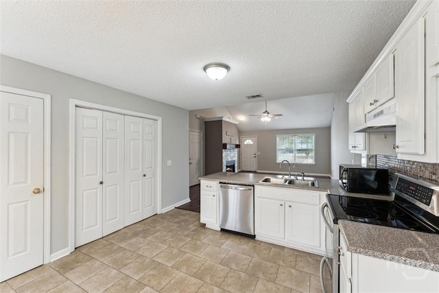 105 Mustang Dr, Guyton, GA 31312 - kitchen with stainless steel appliances, a sink, under cabinet range hood, a peninsula, and white cabinetry