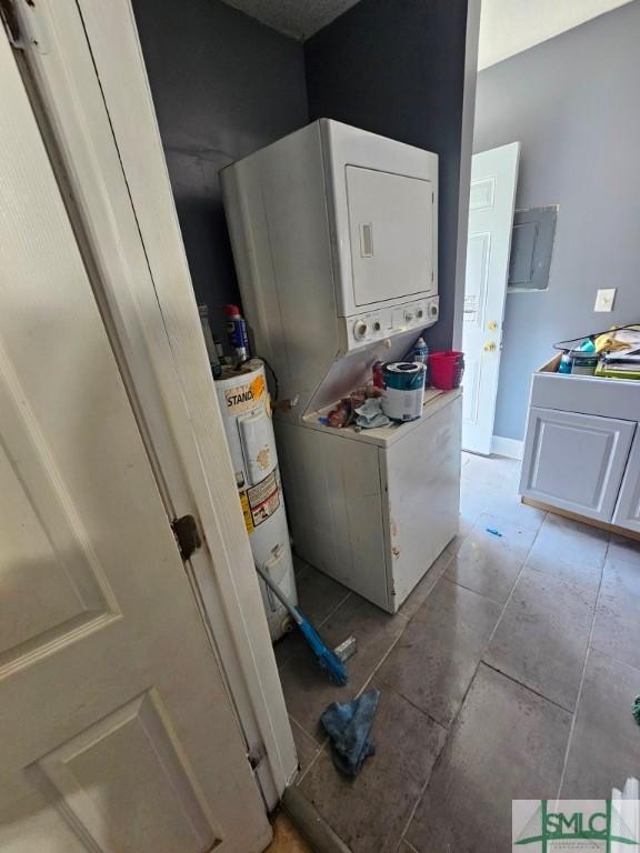 washroom featuring stacked washer and clothes dryer, water heater, electric panel, and light tile patterned floors