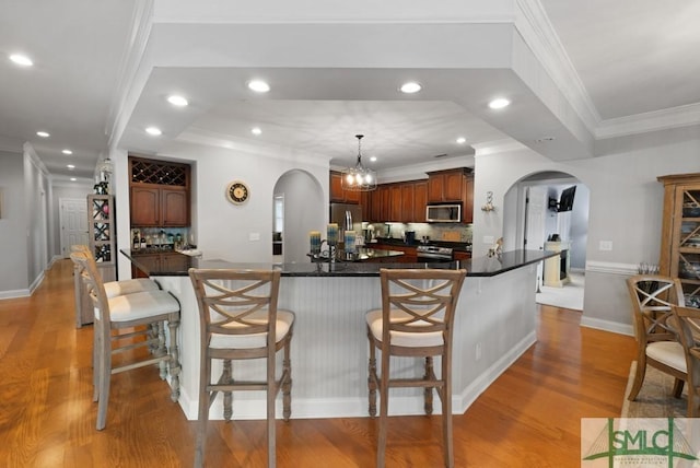 1104 River Oaks Dr Unit 1104, Richmond Hill, GA 31324 - kitchen with arched walkways, appliances with stainless steel finishes, light wood-style flooring, decorative backsplash, and recessed lighting