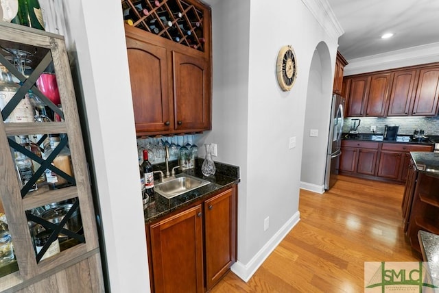1104 River Oaks Dr Unit 1104, Richmond Hill, GA 31324 - indoor wet bar featuring freestanding refrigerator, light wood-style flooring, baseboards, backsplash, and crown molding