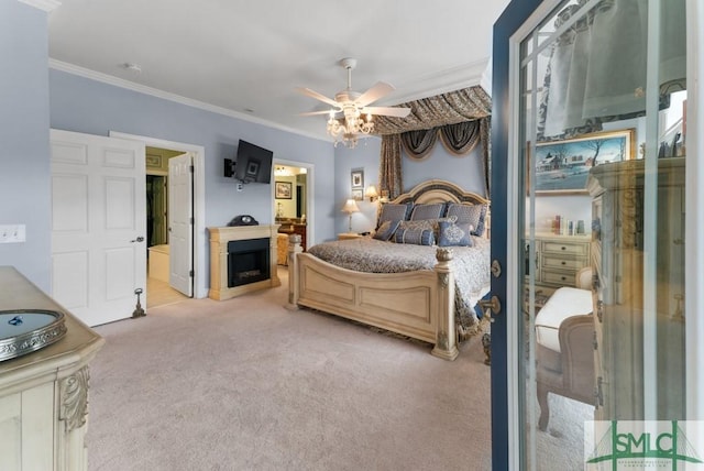carpeted bedroom with crown molding, ensuite bathroom, ceiling fan, and a fireplace