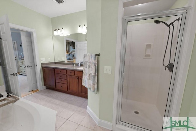 full bath featuring a shower stall, vanity, baseboards, and tile patterned floors