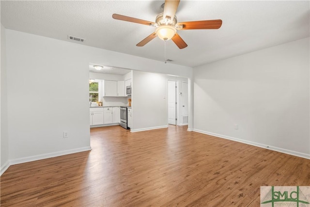 108 Gilliam Ave, Savannah, GA 31406 - unfurnished living room featuring light wood-style flooring, a ceiling fan, and baseboards