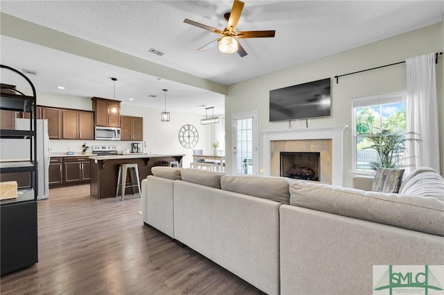 living room featuring a ceiling fan, wood finished floors, a high end fireplace, and recessed lighting