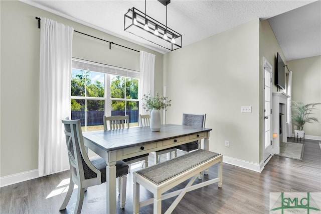 dining area with wood finished floors, baseboards, and a textured ceiling