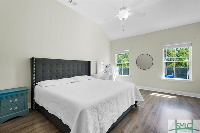 bedroom featuring dark wood finished floors, vaulted ceiling, baseboards, and ceiling fan