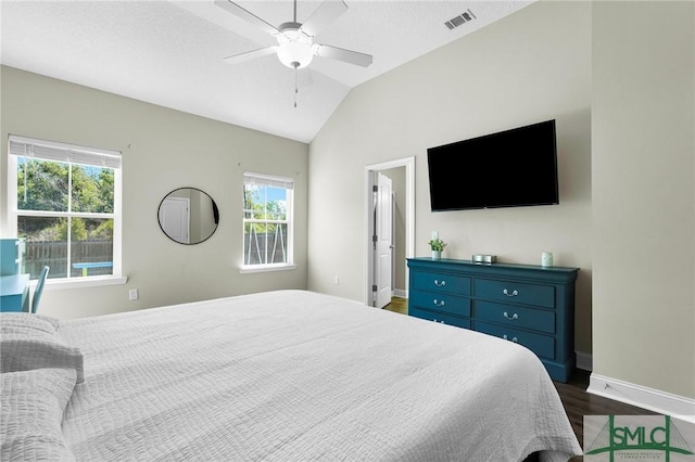 bedroom with dark wood-style floors, lofted ceiling, baseboards, and ceiling fan