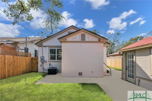 rear view of house featuring a patio, board and batten siding, and central air condition unit