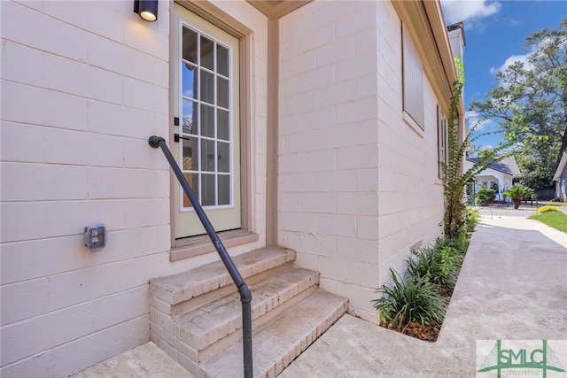 doorway to property featuring concrete block siding