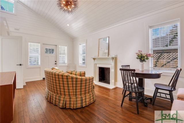 living room with lofted ceiling, hardwood / wood-style flooring, a fireplace with raised hearth, healthy amount of natural light, and wooden ceiling