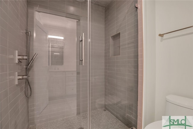 bathroom featuring toilet and a stall shower