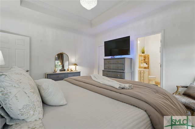 bedroom featuring crown molding, ensuite bathroom, and a tray ceiling