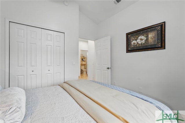 bedroom with lofted ceiling and a closet