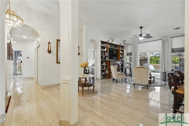 living area featuring ceiling fan, arched walkways, and recessed lighting