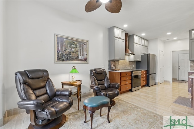 living area featuring a ceiling fan, light wood-style flooring, recessed lighting, and baseboards