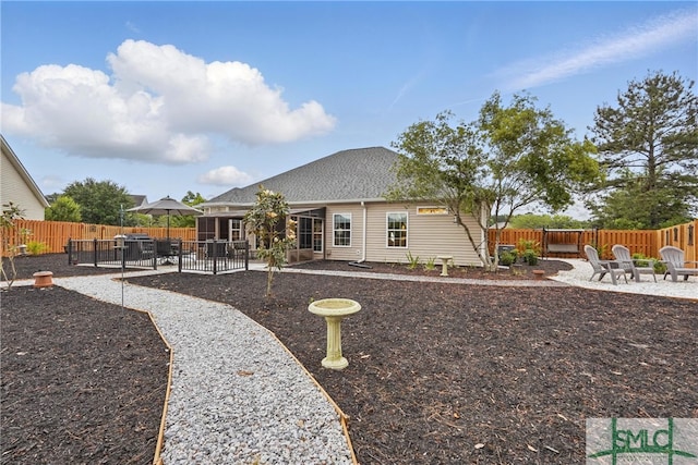 back of house featuring a patio area, a fenced backyard, a shingled roof, and a fire pit