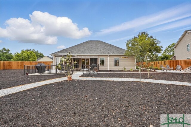 rear view of house with a patio area, a fenced backyard, and roof with shingles