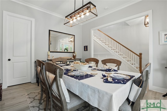 240 Blackjack Oak Dr W, Richmond Hill, GA 31324 - dining space featuring stairs, a chandelier, light wood-style floors, and crown molding