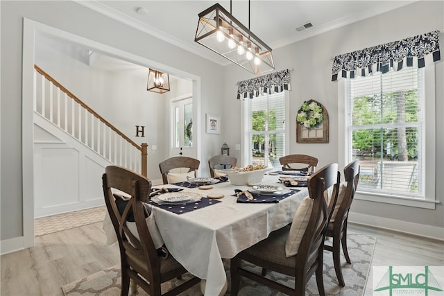 240 Blackjack Oak Dr W, Richmond Hill, GA 31324 - dining space featuring stairway, ornamental molding, light wood finished floors, a chandelier, and baseboards