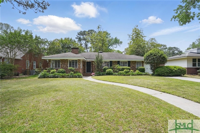 ranch-style home with a chimney, a front yard, and brick siding