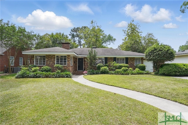 ranch-style house featuring a front yard, a chimney, and brick siding