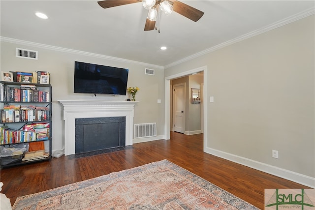 living area with crown molding, wood finished floors, ceiling fan, baseboards, and a fireplace with flush hearth