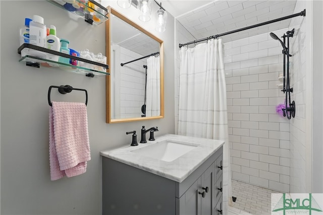 bathroom featuring a tile shower and vanity