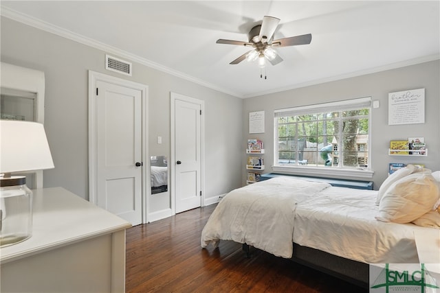 bedroom with dark wood-style floors, crown molding, and a ceiling fan