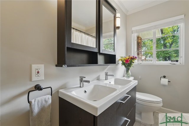 bathroom featuring crown molding, toilet, double vanity, and baseboards