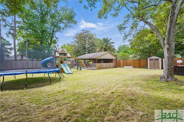 view of yard featuring a trampoline, a playground, a shed, and an outbuilding