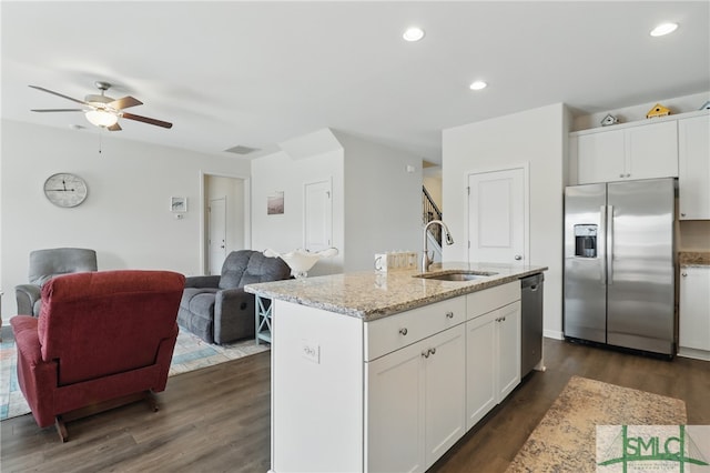 kitchen with appliances with stainless steel finishes, a sink, dark wood finished floors, open floor plan, and recessed lighting