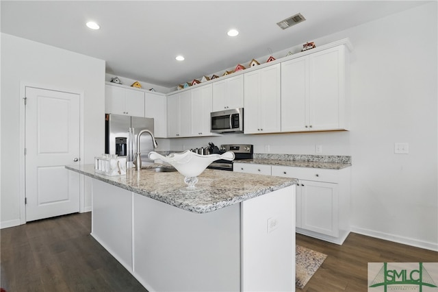 kitchen featuring stainless steel appliances, a sink, dark wood-type flooring, white cabinetry, and recessed lighting