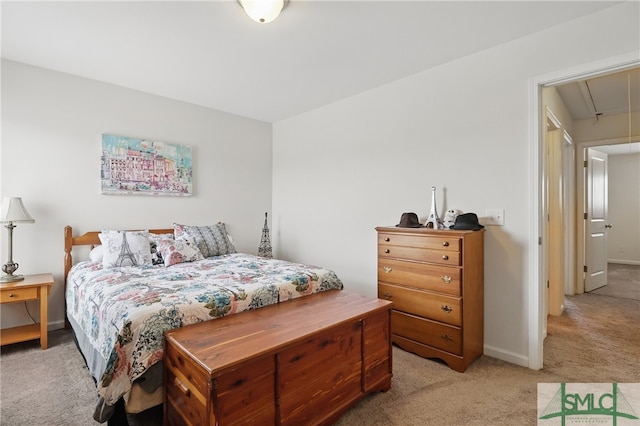 bedroom featuring light carpet, attic access, and baseboards