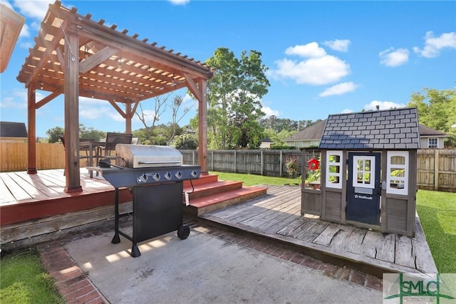113 Taylor Ct, Richmond Hill, GA 31324 - wooden terrace featuring a fenced backyard, a pergola, an outbuilding, area for grilling, and a storage unit