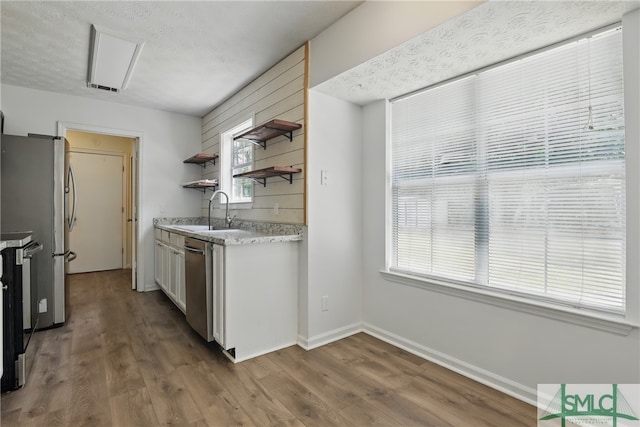 57 Cut Off Way, Richmond Hill, GA 31324 - kitchen featuring a sink, open shelves, appliances with stainless steel finishes, wood finished floors, and baseboards