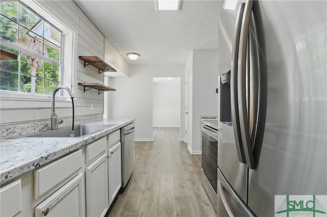 57 Cut Off Way, Richmond Hill, GA 31324 - kitchen featuring appliances with stainless steel finishes, a sink, open shelves, light countertops, and light wood-type flooring