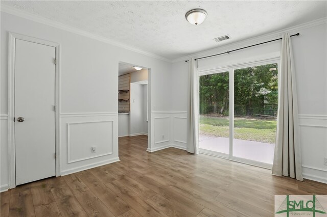 57 Cut Off Way, Richmond Hill, GA 31324 - unfurnished bedroom with access to exterior, a decorative wall, a textured ceiling, wood finished floors, and ornamental molding
