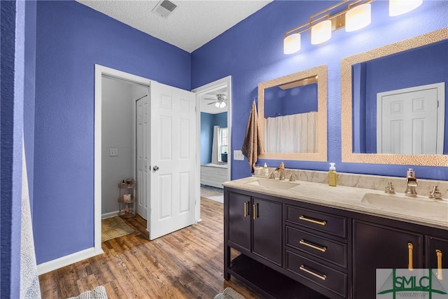 38 Travertine Cir, Savannah, GA 31419 - full bath with wood finished floors, double vanity, baseboards, a textured wall, and a ceiling fan