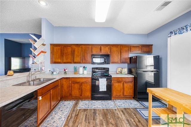38 Travertine Cir, Savannah, GA 31419 - kitchen featuring black appliances, a sink, light wood-type flooring, light countertops, and vaulted ceiling