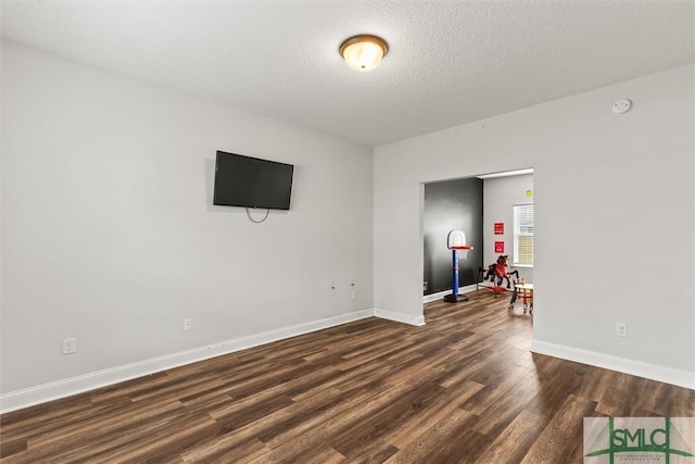 110 Richmond Pass Cir, Midway, GA 31320 - empty room with dark wood finished floors, a textured ceiling, and baseboards