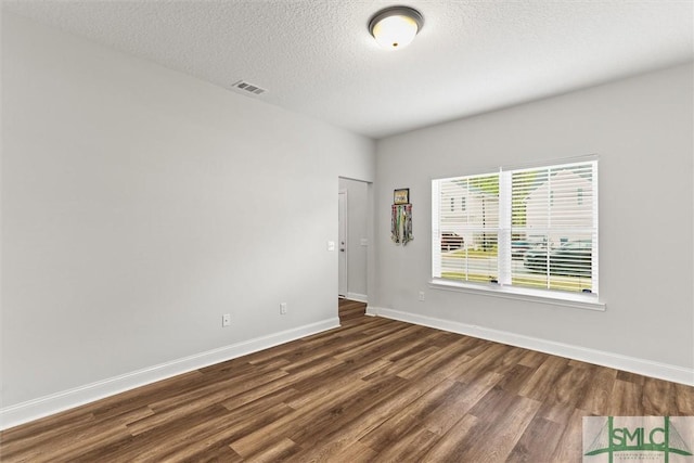 110 Richmond Pass Cir, Midway, GA 31320 - empty room featuring dark wood-style flooring, baseboards, and a textured ceiling