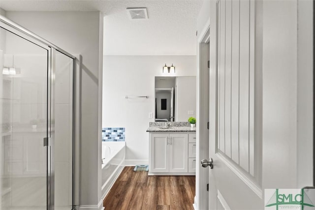 110 Richmond Pass Cir, Midway, GA 31320 - full bathroom with a garden tub, a shower stall, vanity, wood finished floors, and a textured ceiling