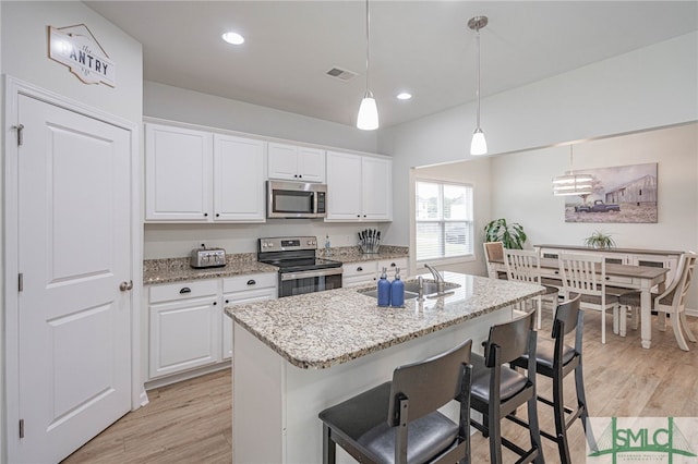 128 Greenbriar Dr, Guyton, GA 31312 - kitchen with appliances with stainless steel finishes, a sink, white cabinets, light wood-type flooring, and light stone counters