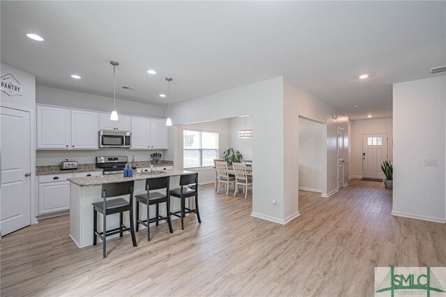 128 Greenbriar Dr, Guyton, GA 31312 - kitchen featuring appliances with stainless steel finishes, white cabinets, light wood-type flooring, a kitchen island with sink, and recessed lighting