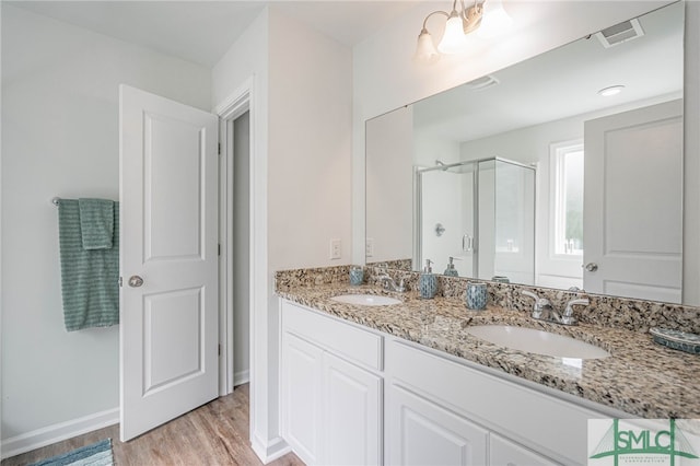 128 Greenbriar Dr, Guyton, GA 31312 - bathroom with a stall shower, wood finished floors, double vanity, and baseboards