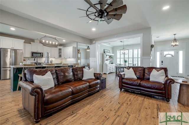 201 Cumberland Pt, Statesboro, GA 30458 - living area featuring ceiling fan, a decorative wall, a chandelier, light wood finished floors, and a wainscoted wall