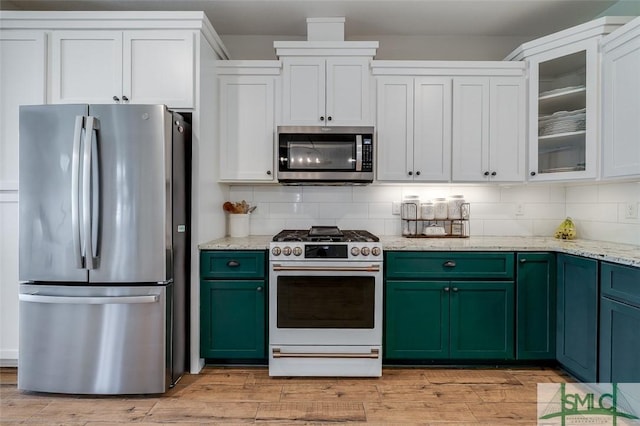 201 Cumberland Pt, Statesboro, GA 30458 - kitchen featuring appliances with stainless steel finishes, green cabinetry, decorative backsplash, and white cabinetry