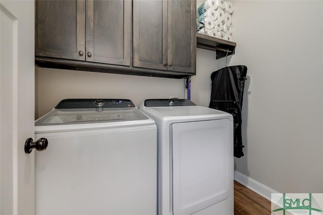 201 Cumberland Pt, Statesboro, GA 30458 - clothes washing area with washing machine and dryer, baseboards, cabinet space, and wood finished floors