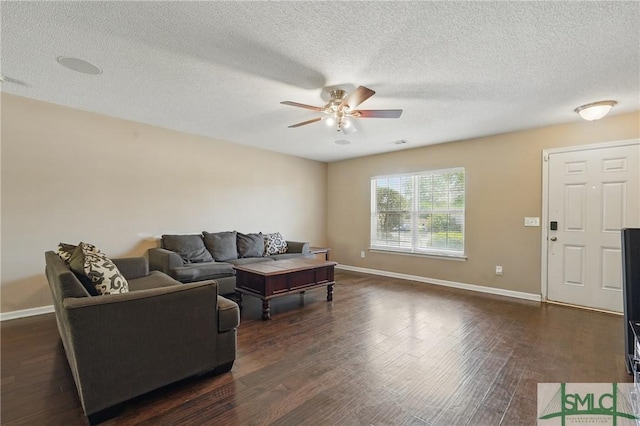 living room with ceiling fan, baseboards, dark wood-type flooring, and a textured ceiling